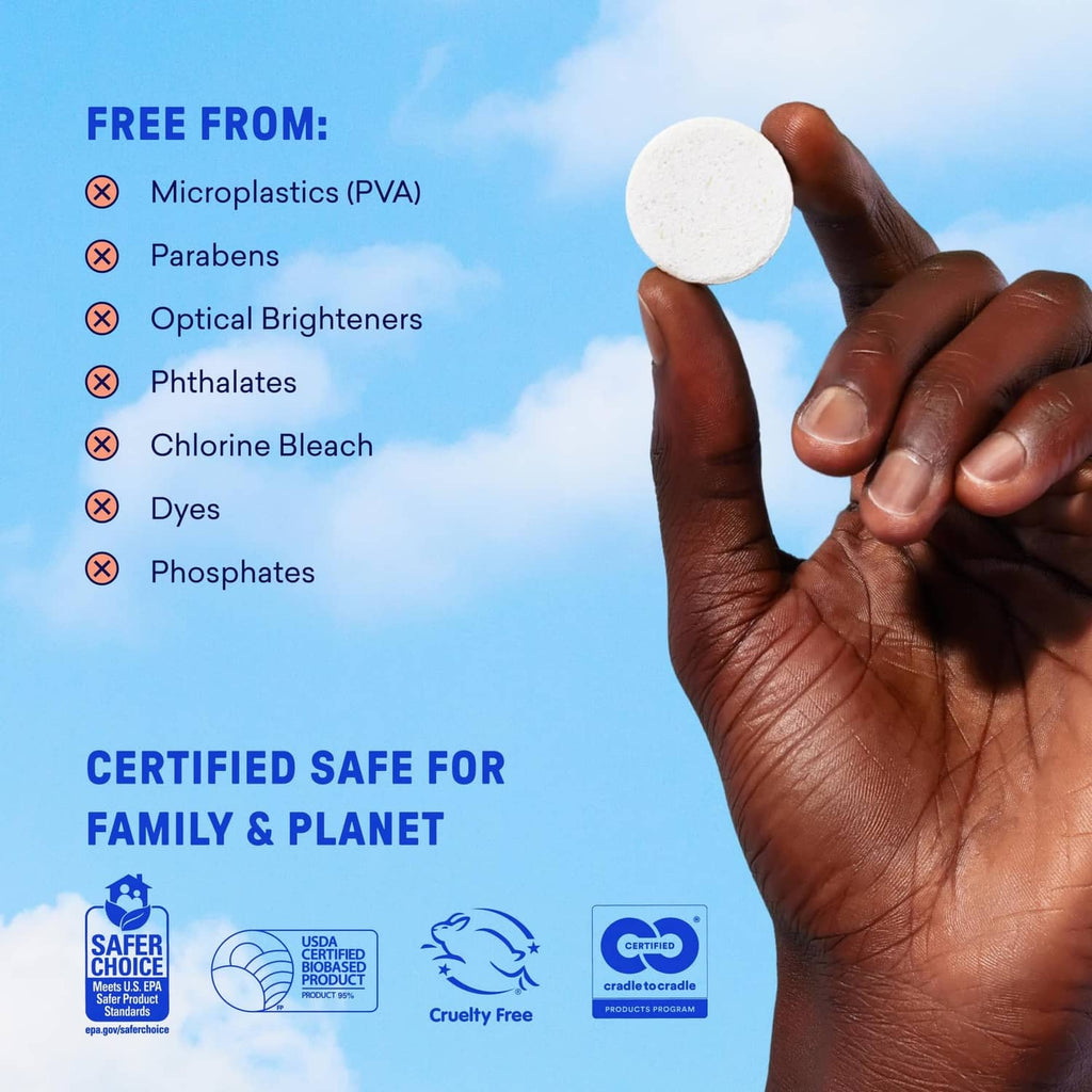 Small white laundry detergent tablet held between fingers