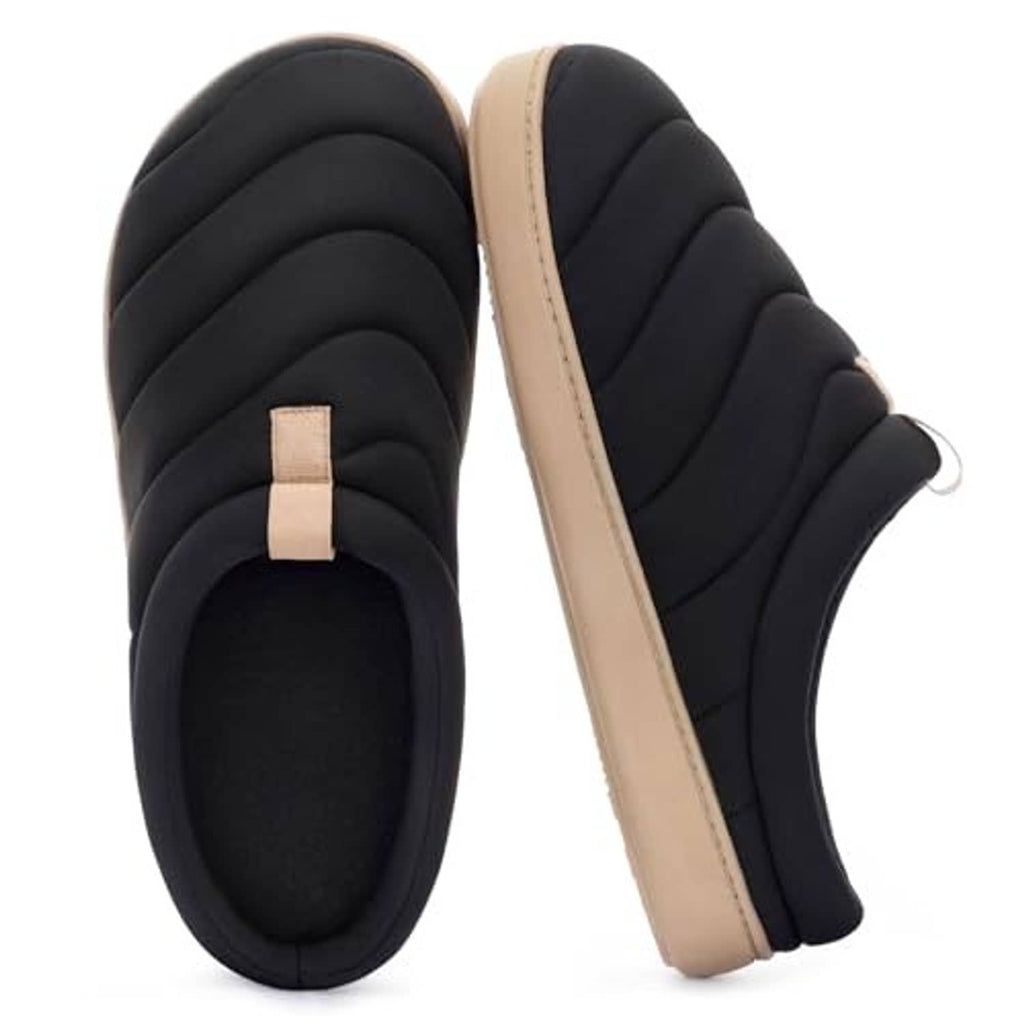 Black slip-on slippers with quilted upper and beige side sole trim, angled view.