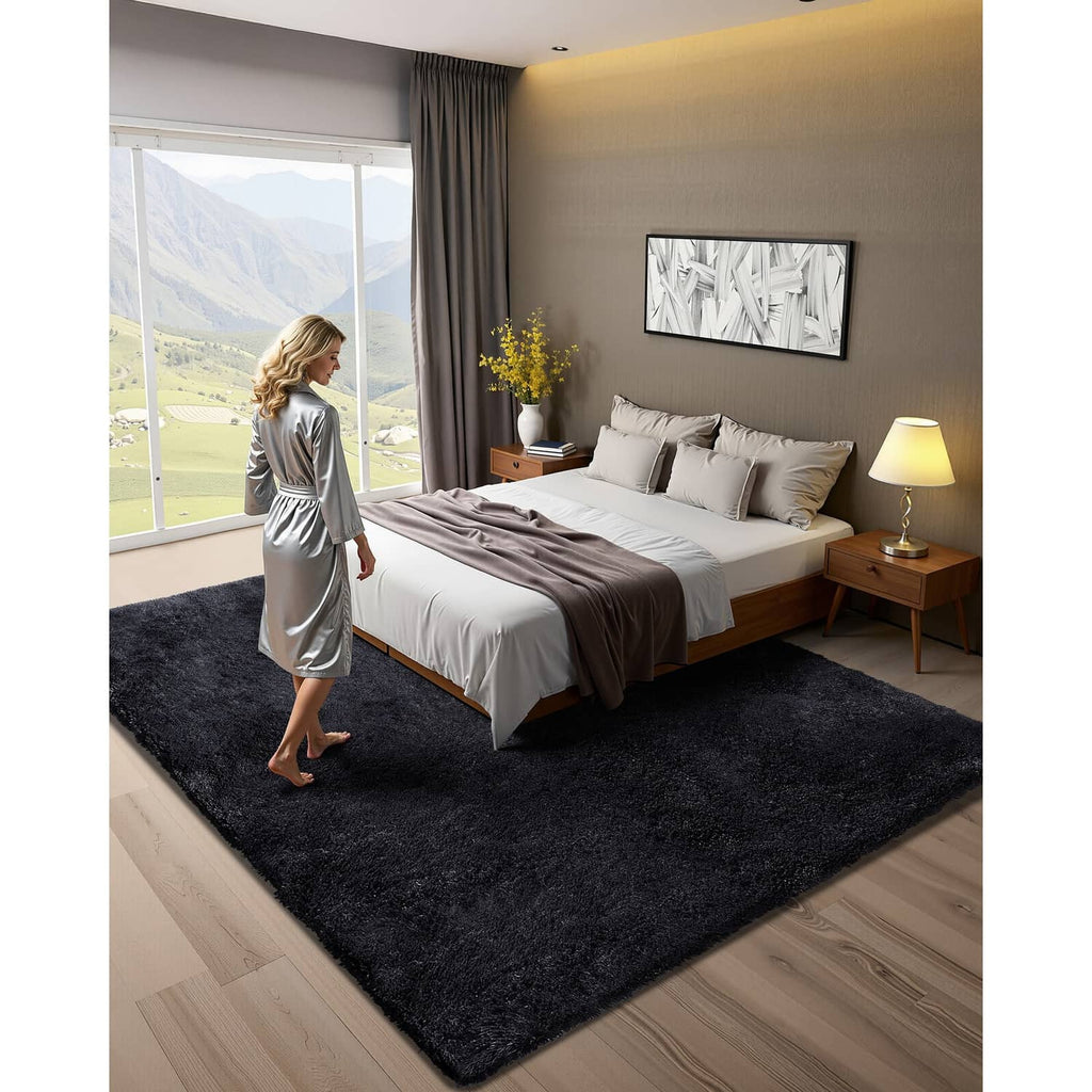 Black plush area rug laid in a bedroom under a bed and bedding setup