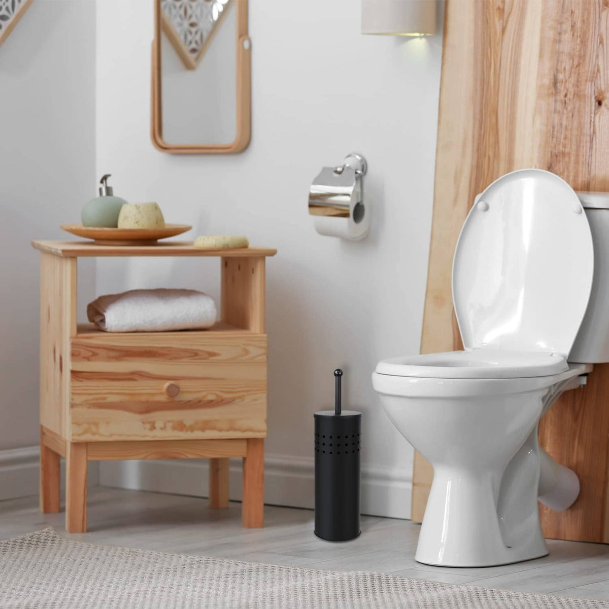 Black toilet plunger in a perforated holder beside a white toilet