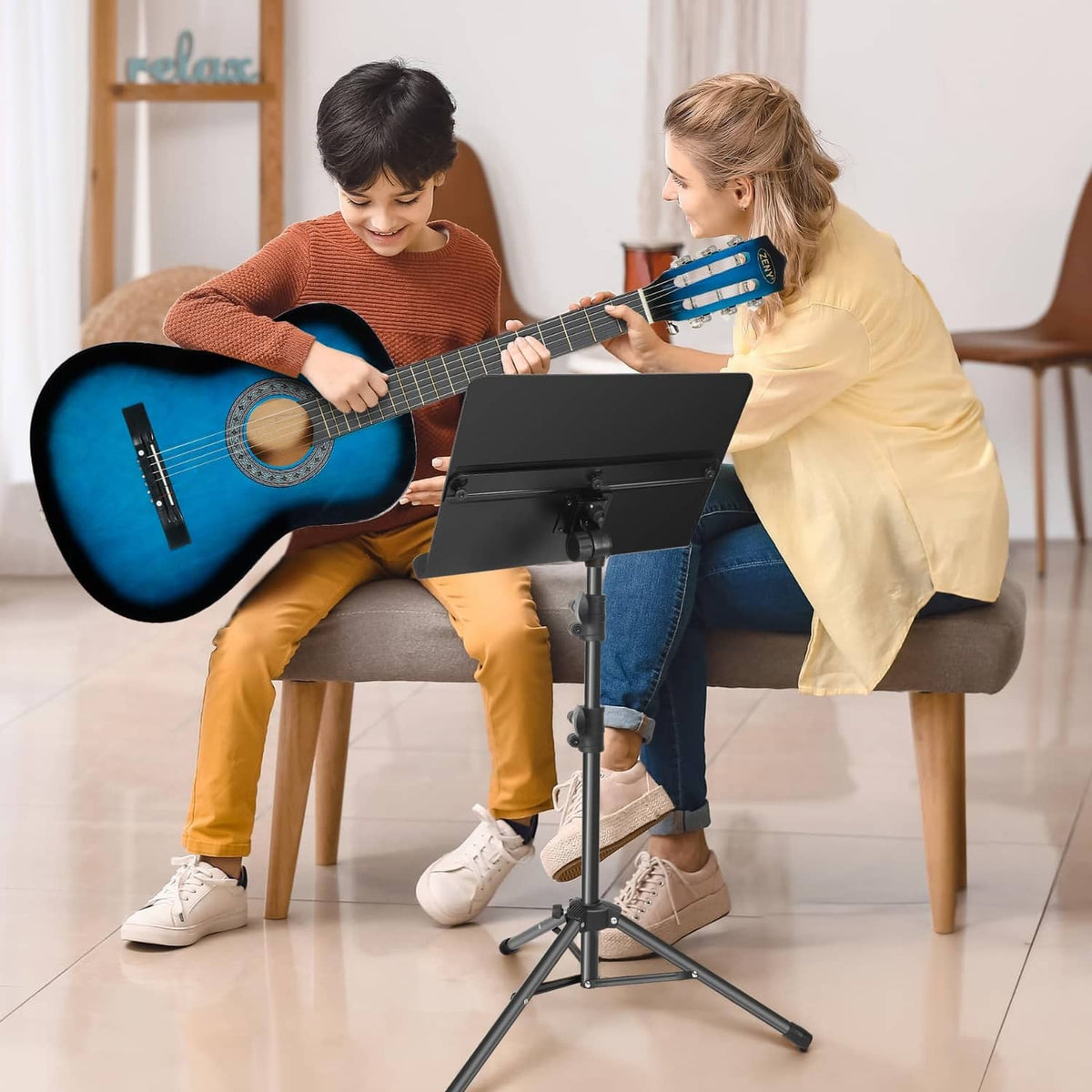 Black portable music stand supporting sheet music while two people play guitar