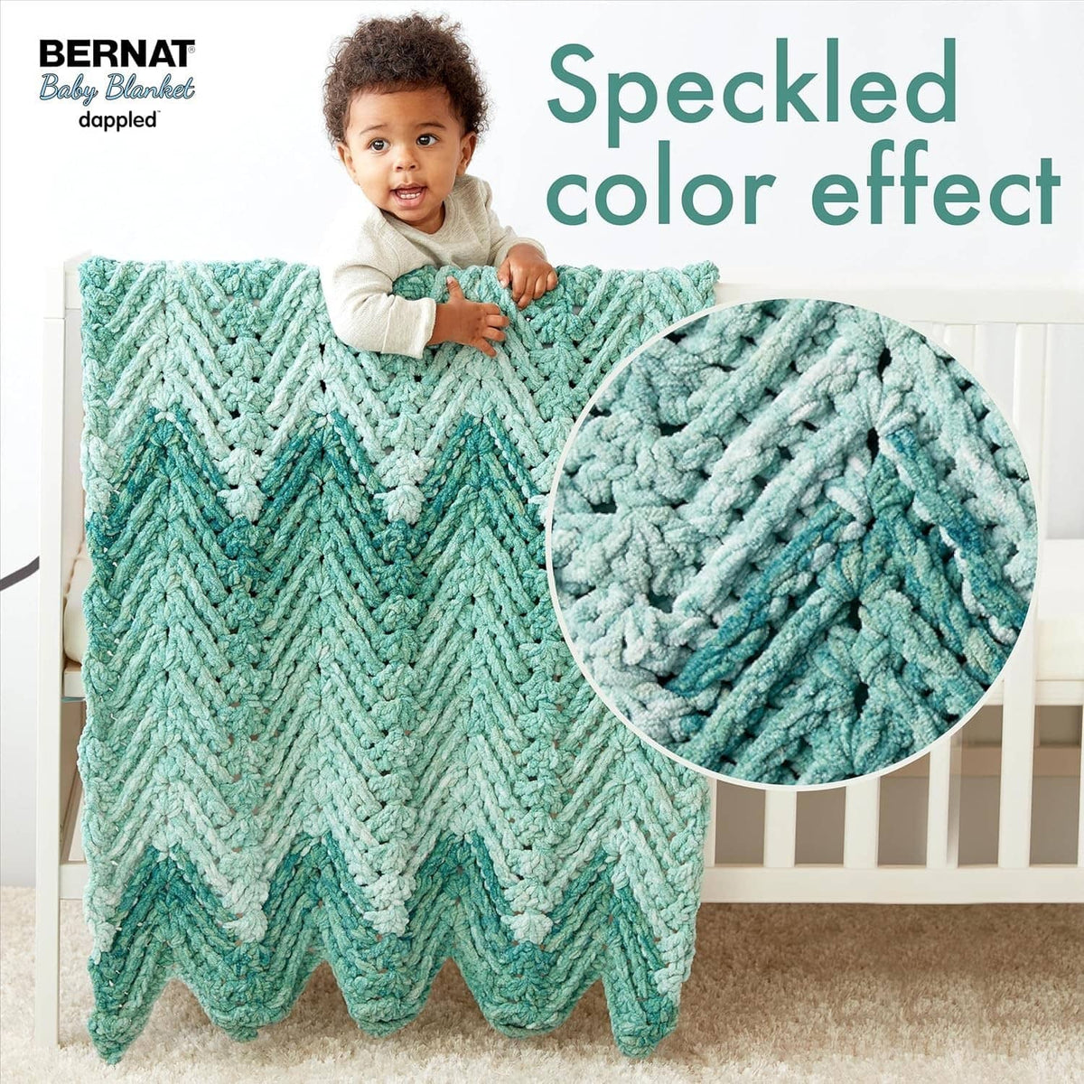 Teal dappled chunky knit baby blanket with raised chevron texture and fringed edge