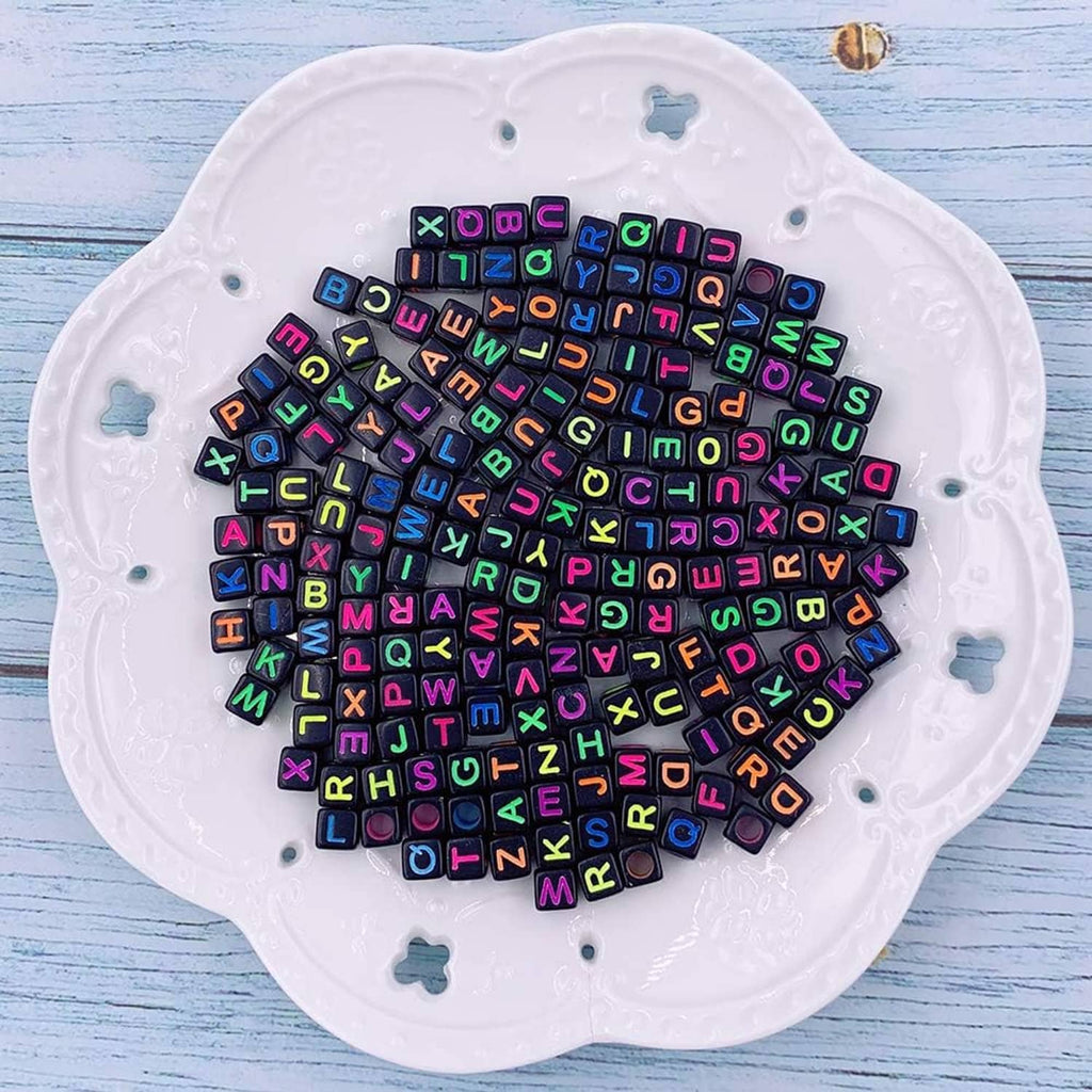 Mixed alphabet and number cube beads on white tray