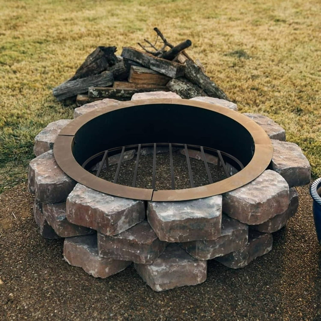 Black round fire pit grate resting inside a stone fire ring opening