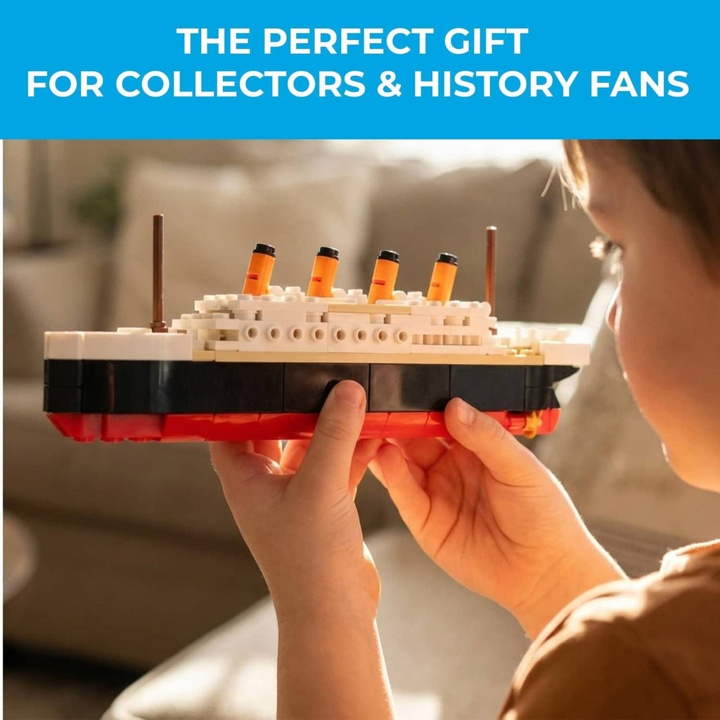 Person holding the assembled multicolor brick Titanic ship model at chest height