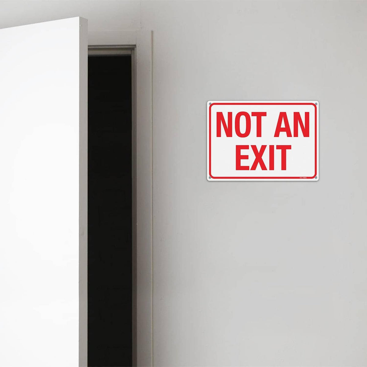 Wall-mounted red “NOT AN EXIT” sign plaque with white frame