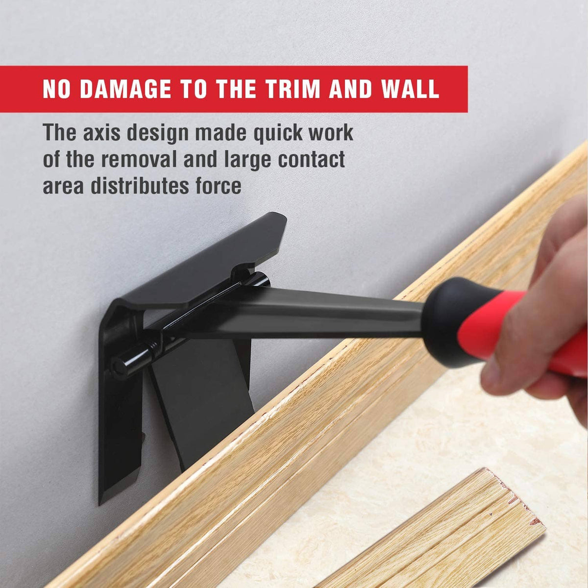 Trim puller tool with black head and red grip prying up baseboard from wall