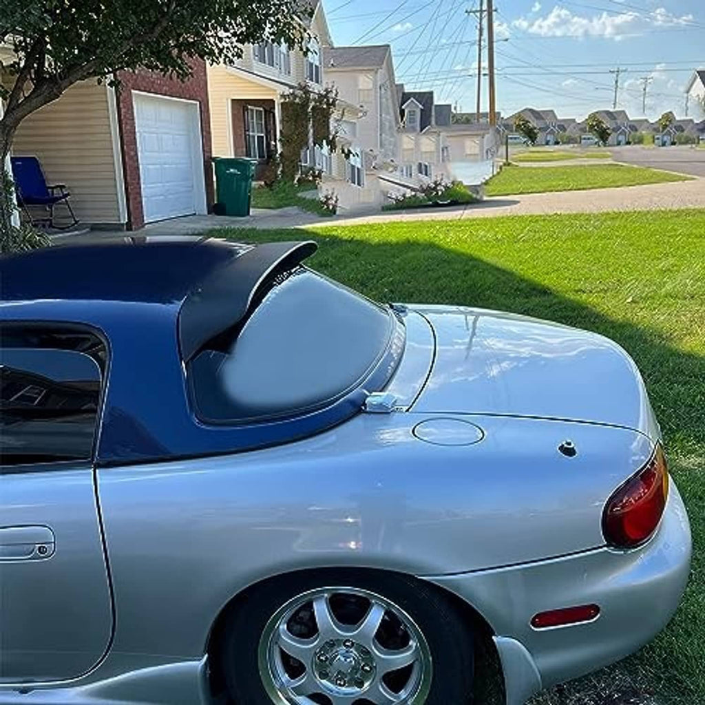 Matte black rear window roof spoiler installed on a blue hardtop car rear