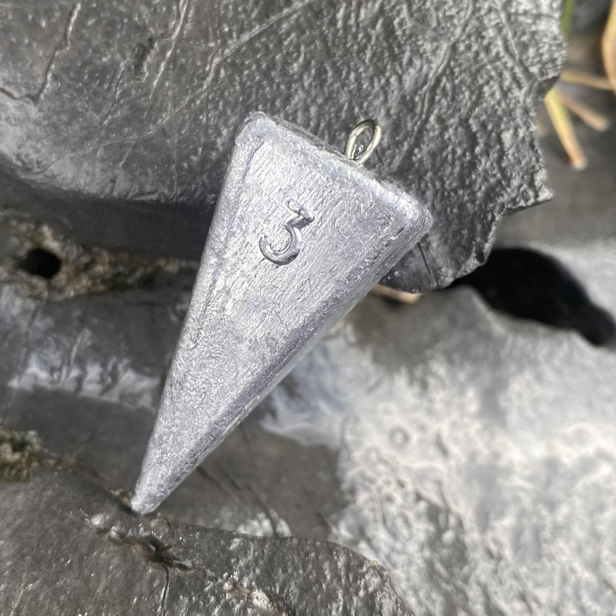 Grey pyramid sinker weight with stamped number and metal loop ring