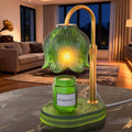 Green flower-style candle warmer lamp with gold stand and glowing glass shade