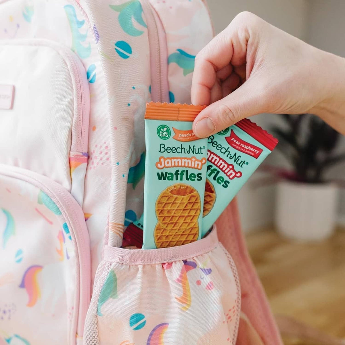 Child holding Beech-Nut Jammin' Waffles snack pack in front pocket