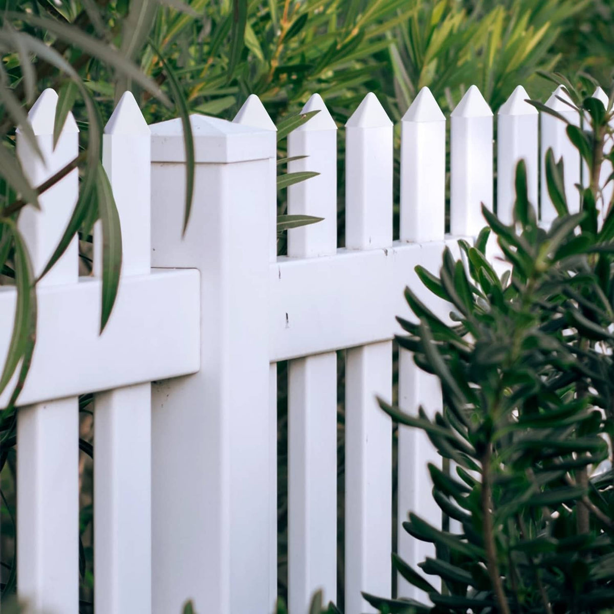 White vinyl picket fence caps on fence top rails and post ends