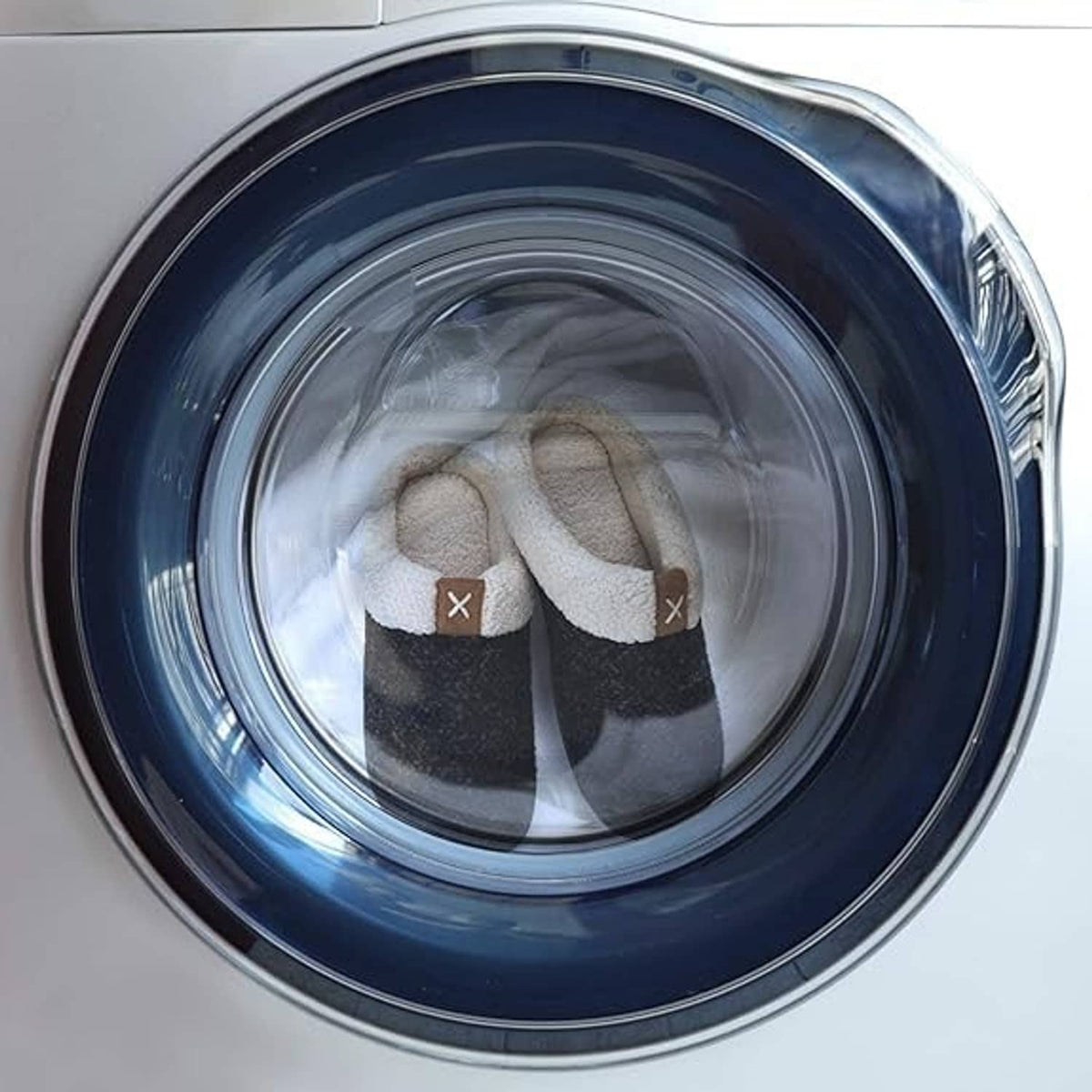 Pair of sherpa-lined slip-on slippers inside a washing machine drum
