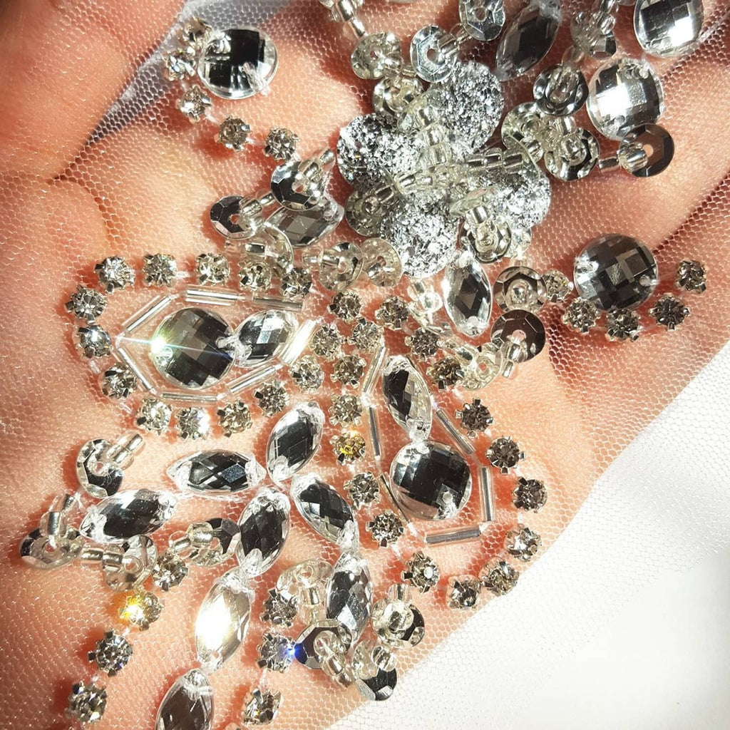 Close-up of faceted rhinestones and crystal beads on mesh sequin trim