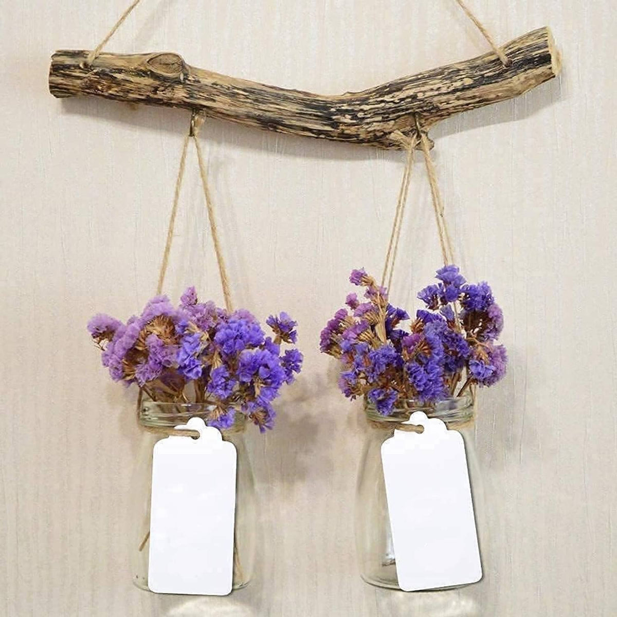 Two white blank paper gift tags hanging on twine loops