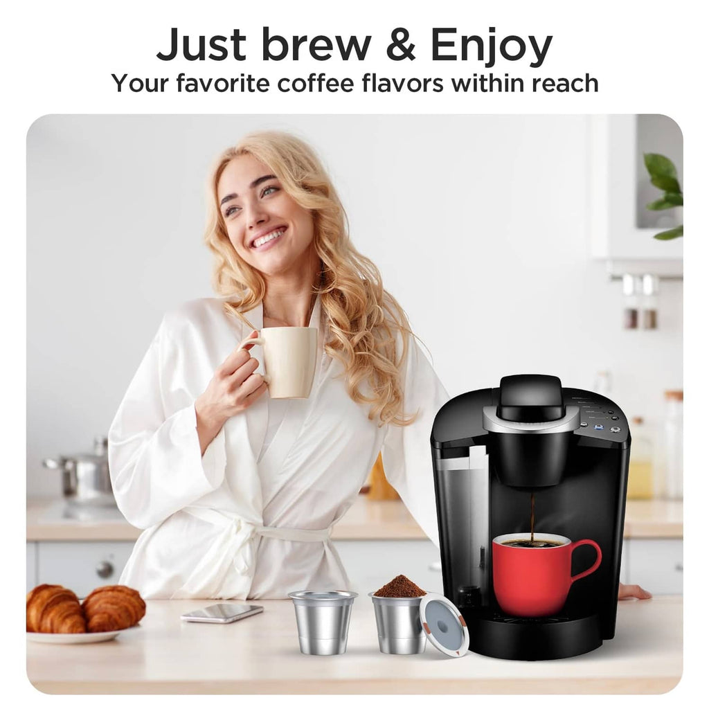 Stainless steel reusable K-cup coffee filter pods, shown with a small metal cup
