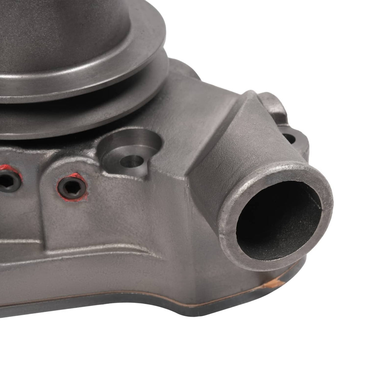 Water pump outlet and mounting holes on gray cast metal housing, close-up