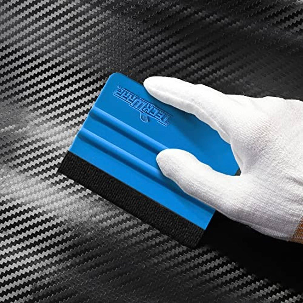 Blue squeegee scraper held in glove, black felt edge contacting the surface