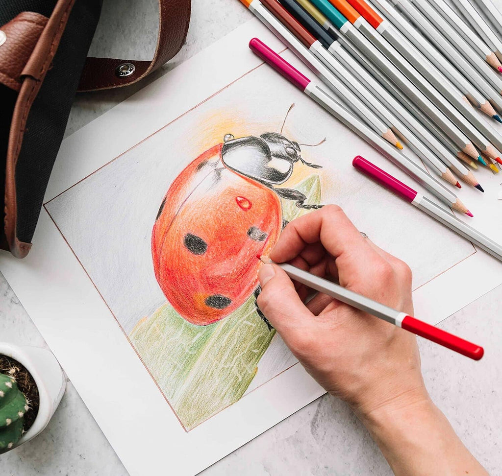 White cardboard art sheet with a hand-drawn design and colored pencils