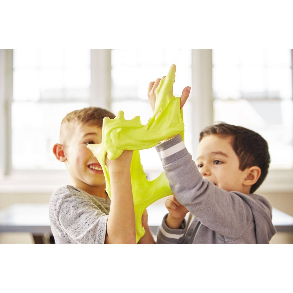 Children holding bright green slime with a school glue bottle nearby