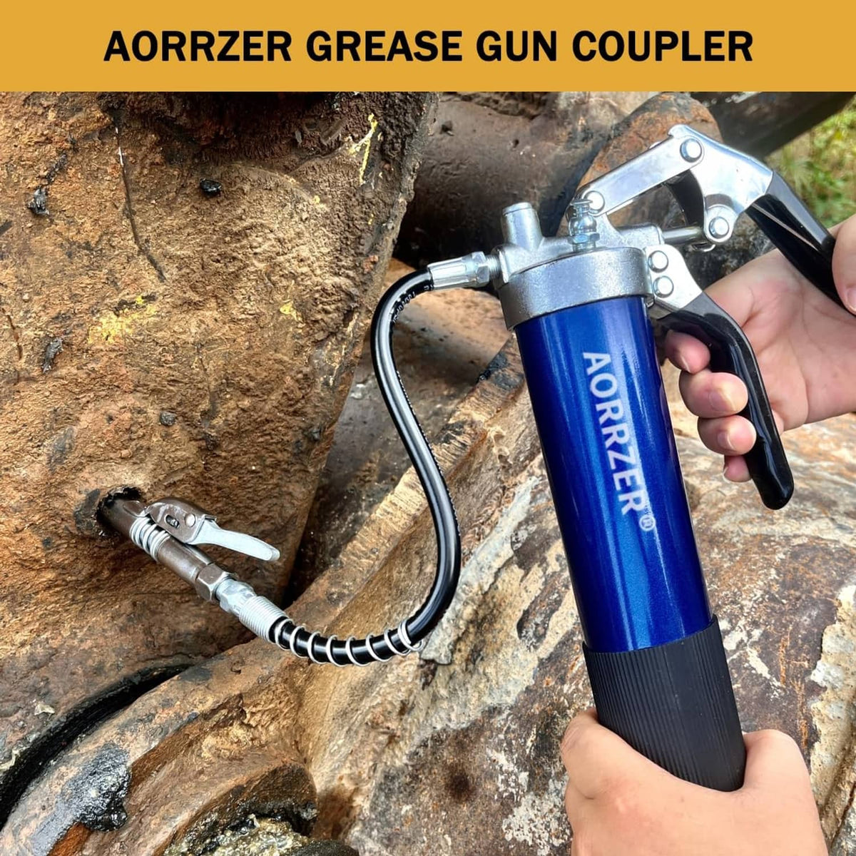 Blue grease gun with silver coupler and hose in use on rusted metal