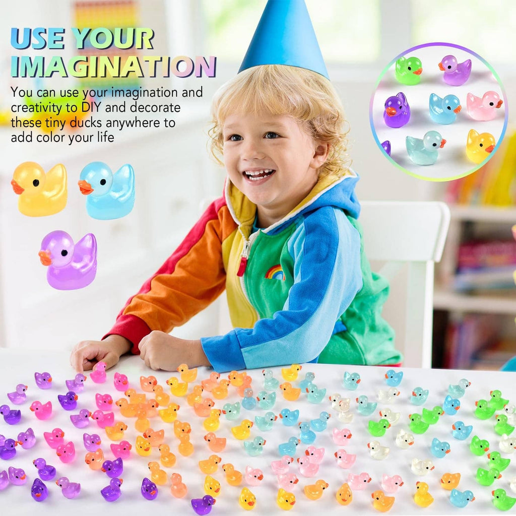 Mini luminous resin duck figurines scattered across a flat surface in bright colors