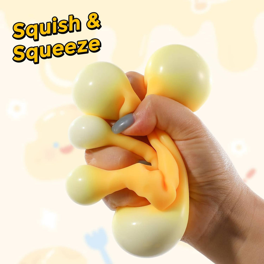 Yellow cheese squishy fidget toy with rounded holes, hand squeezing