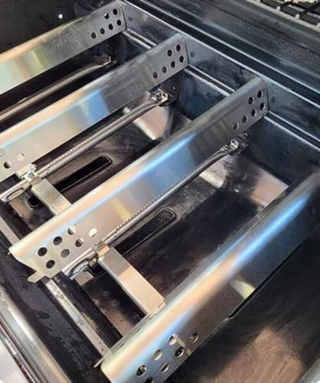 Installed stainless steel heat plates and burner tubes inside a gas grill firebox