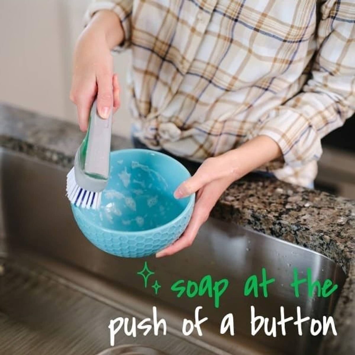 Dishwand brush scrubbing a blue bowl with blue-and-white bristle head