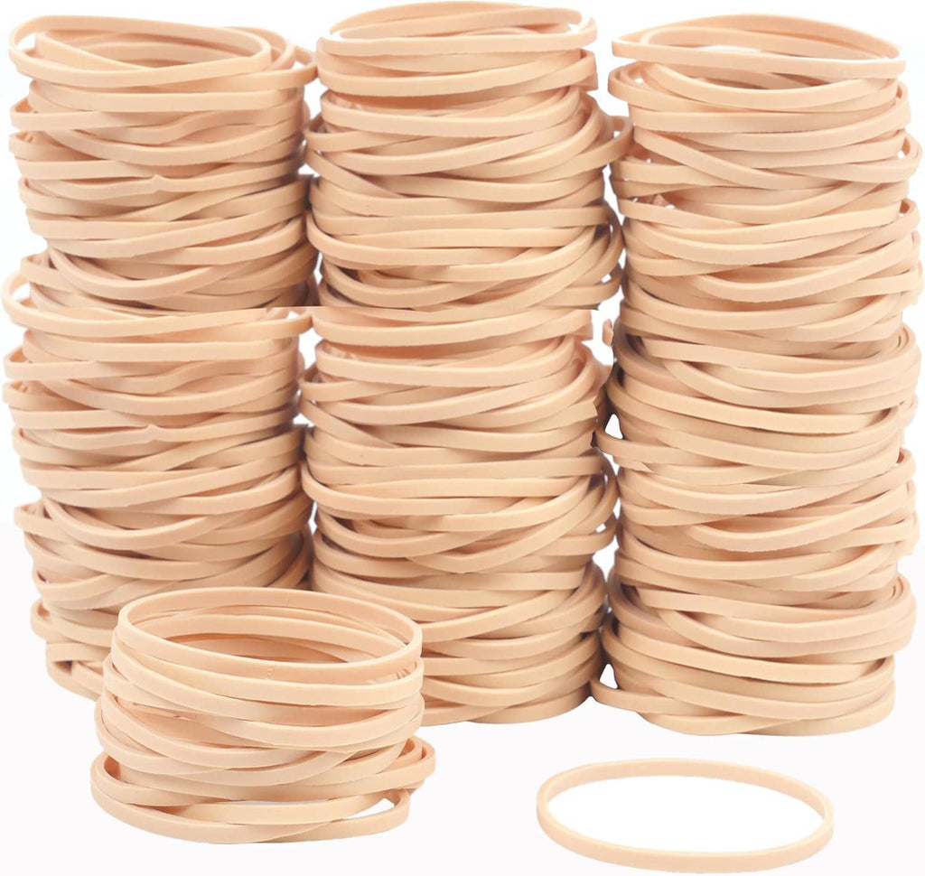 Beige elastic rubber bands in three tall stacks with one loose ring