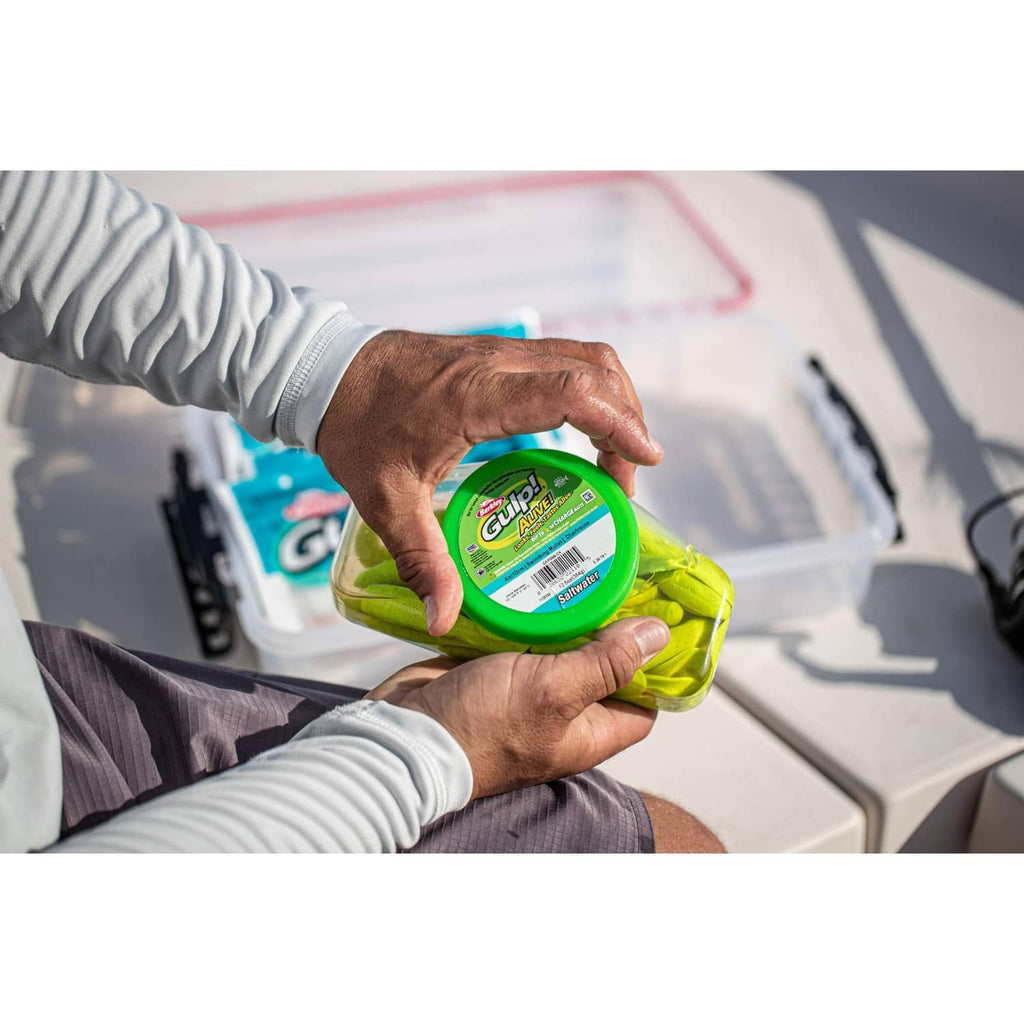 Green soft fishing bait container being opened in hands