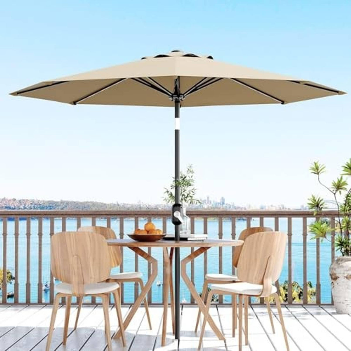 Tan 9 ft patio umbrella centered above outdoor dining set