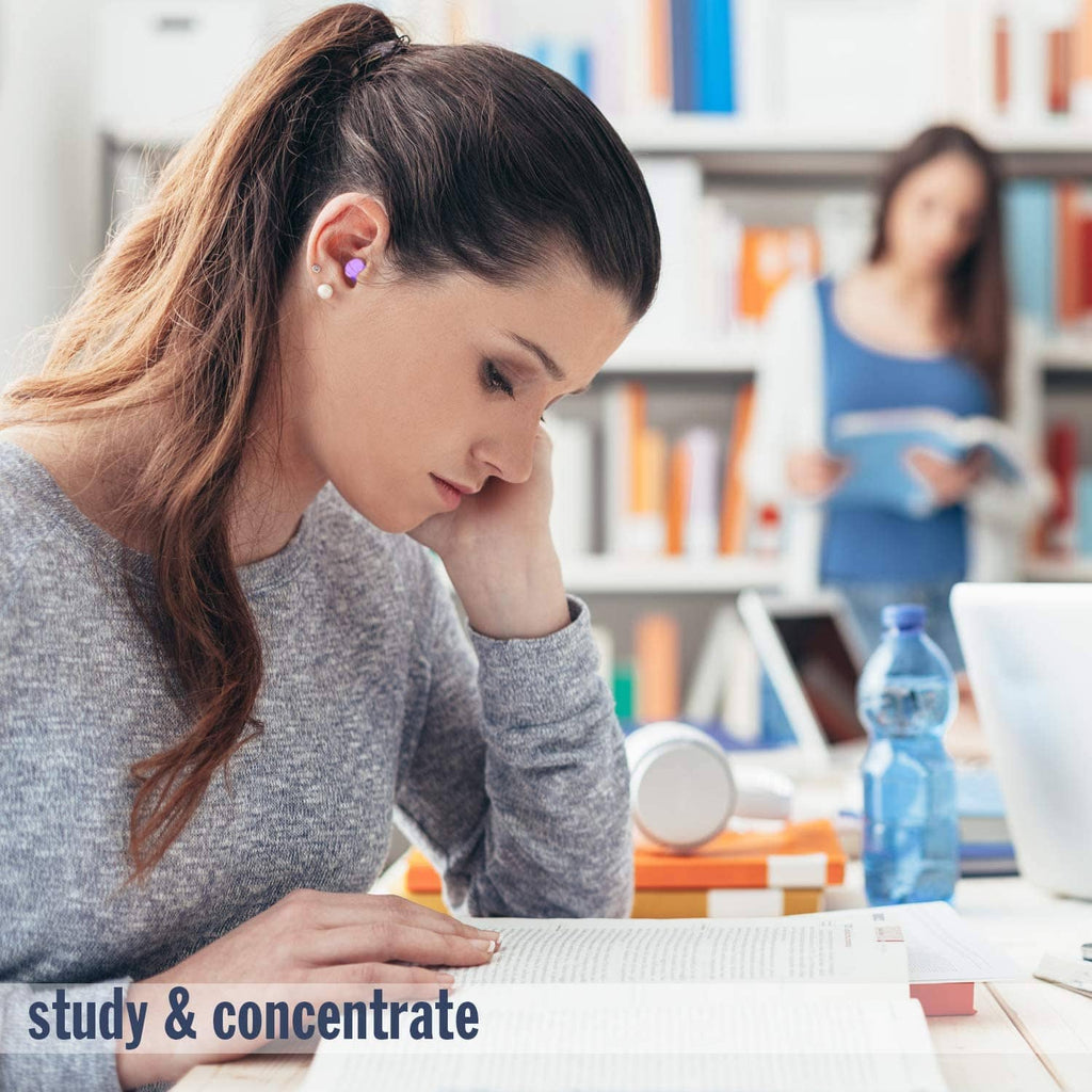 Purple foam earplug in ear while studying at a desk, small earplug visible