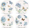 Set of four blue floral dessert plates with butterflies on white, scalloped rims.