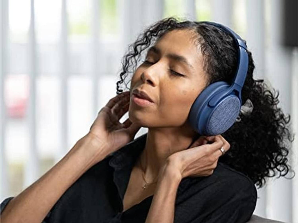 Person wearing navy blue over-ear headphones with cushioned ear pads