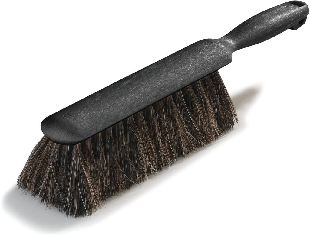 Black counter brush with dense bristles on an angled head and curved handle