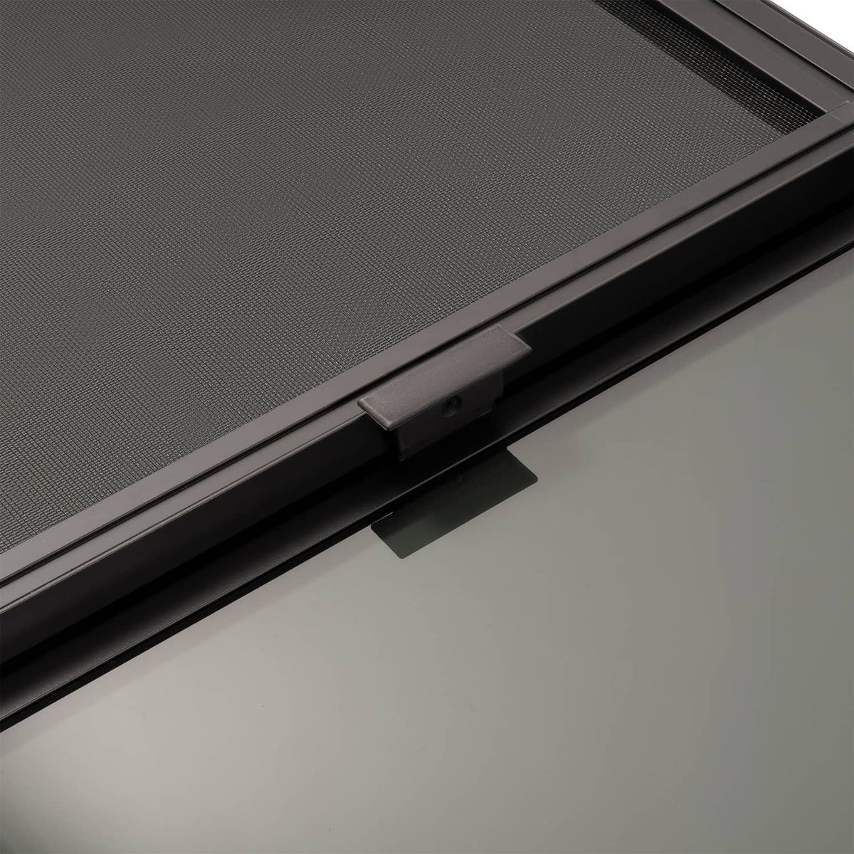 RV window screen insert with sliding track and latch mechanism on a dark frame