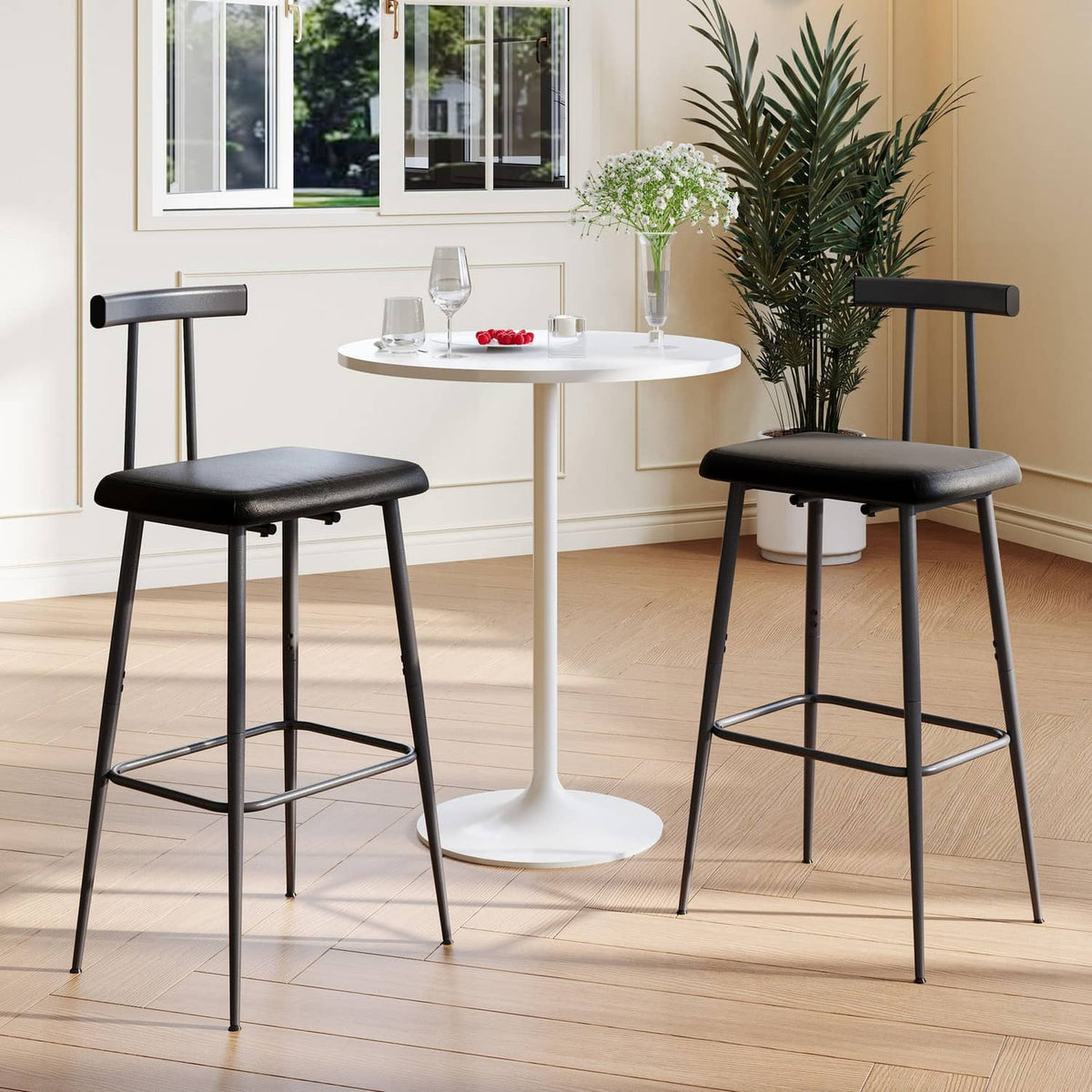 Black bar stools with padded seats, wide backrest, and metal footrests