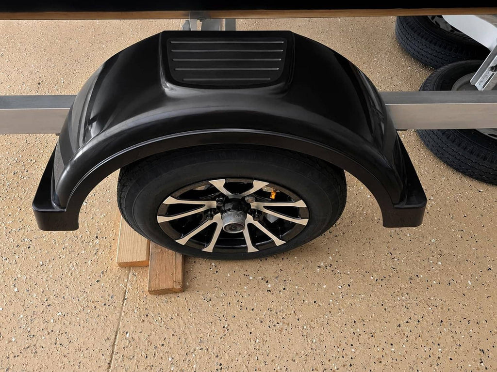 Black curved trailer fender covering a wheel, with raised ridged step on top