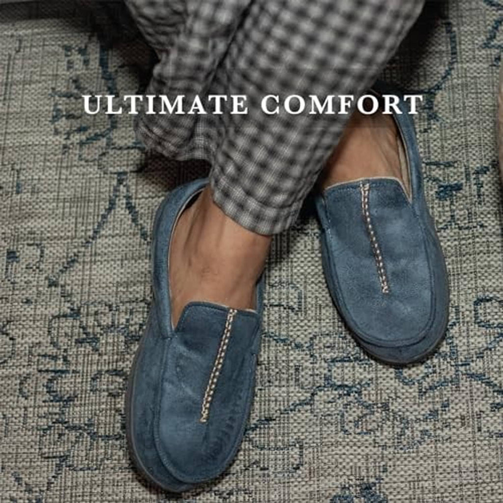 Blue suede-look moccasin slippers with contrast stitching, worn on patterned rug