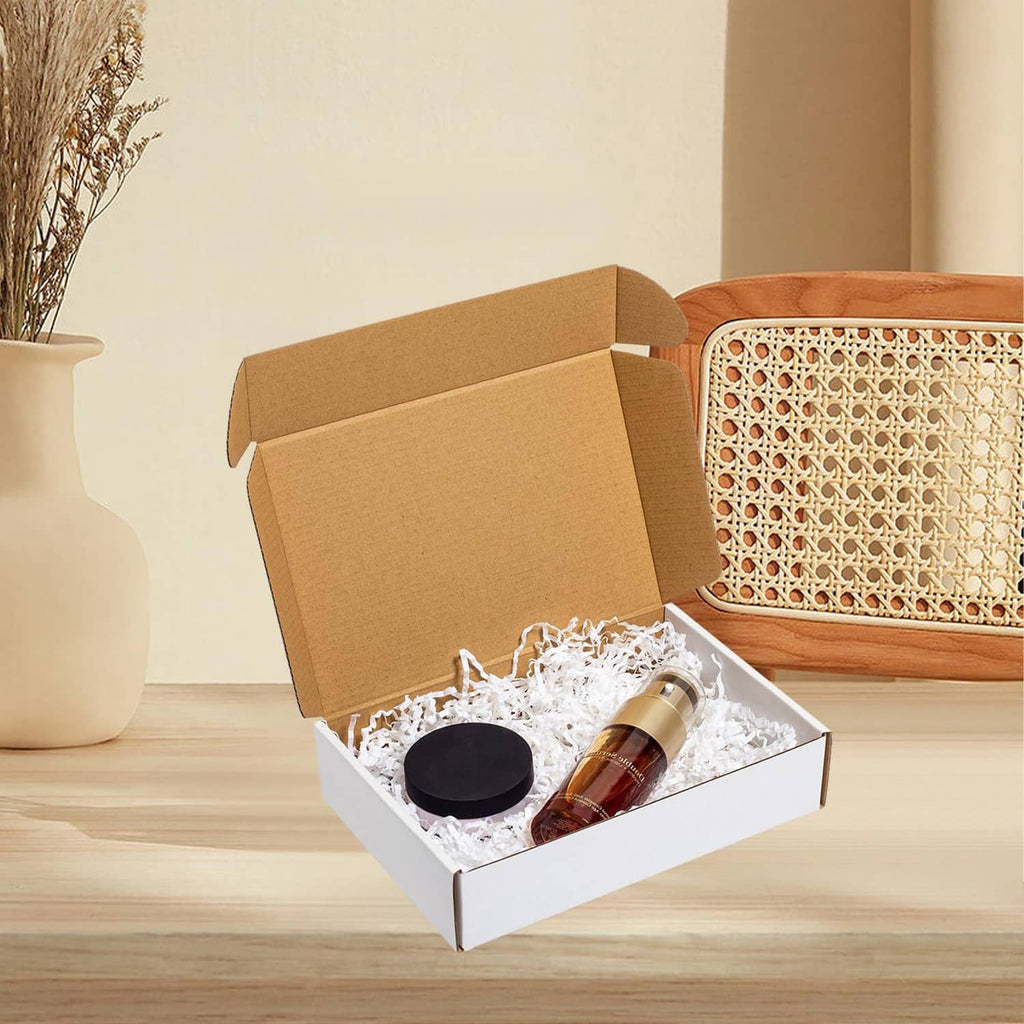 White corrugated shipping box, open with bottle and circular cap items inside