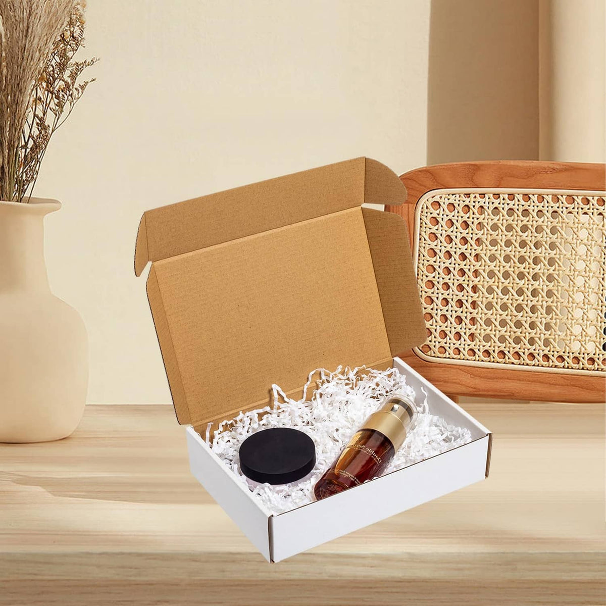 White corrugated shipping box, open with bottle and circular cap items inside