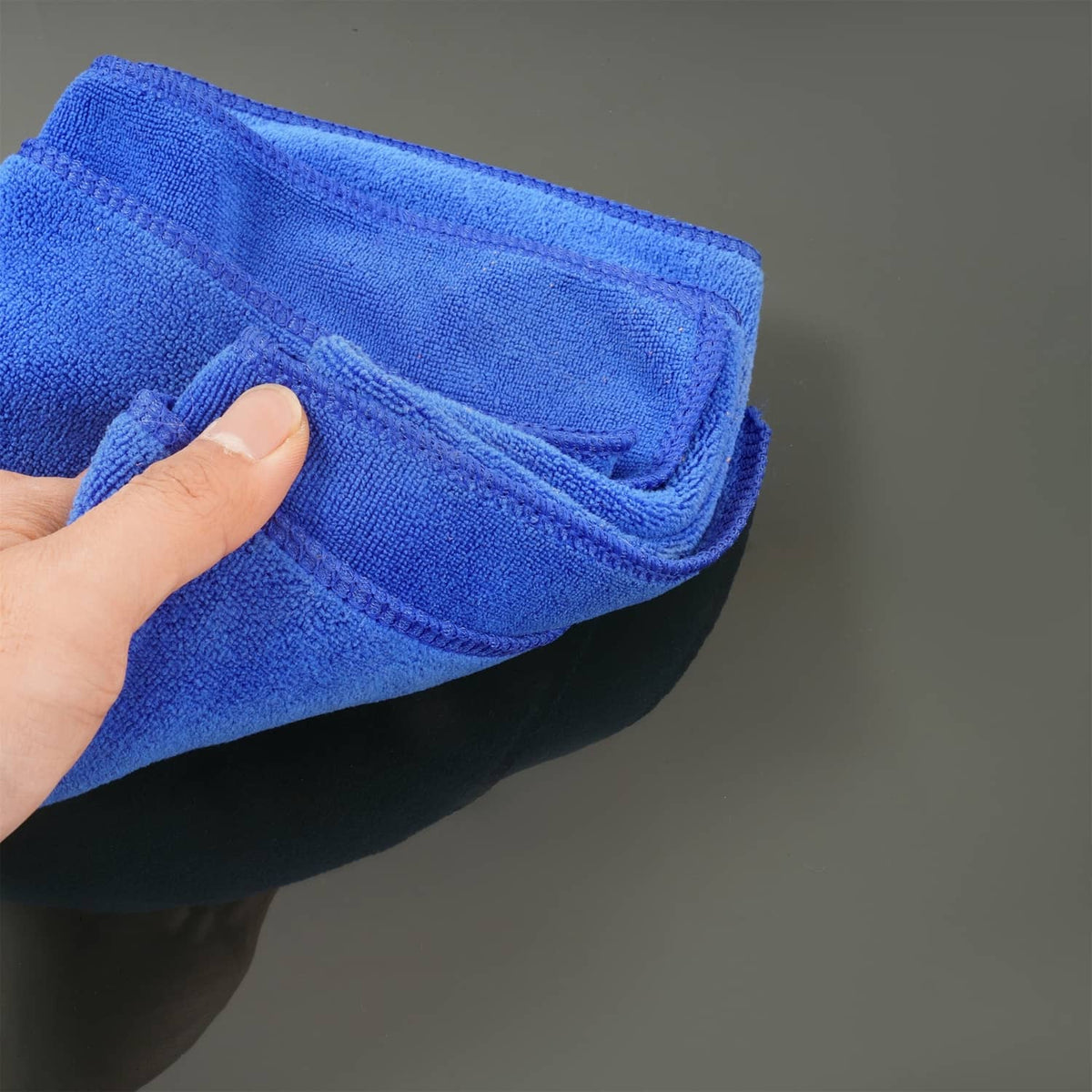 Blue microfiber cloth wiping an RV window screen surface
