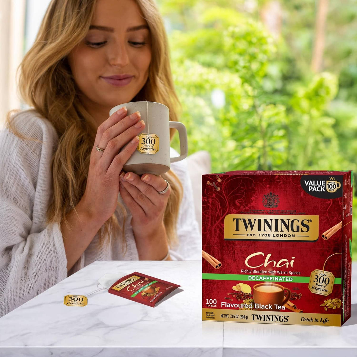 Chai decaffeinated black tea bags box with tea cups and individual tea sachet on table