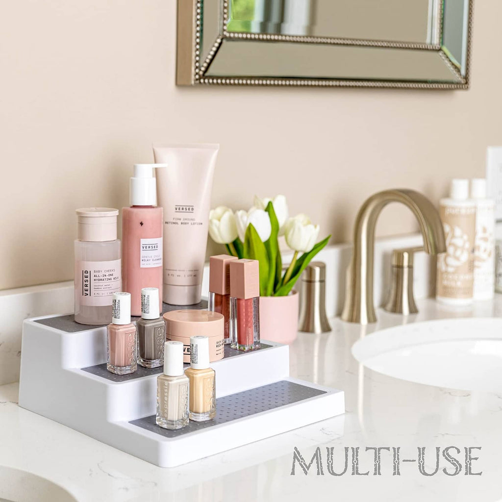 White 3-tier spice rack on countertop holding assorted spice jars and bottles.