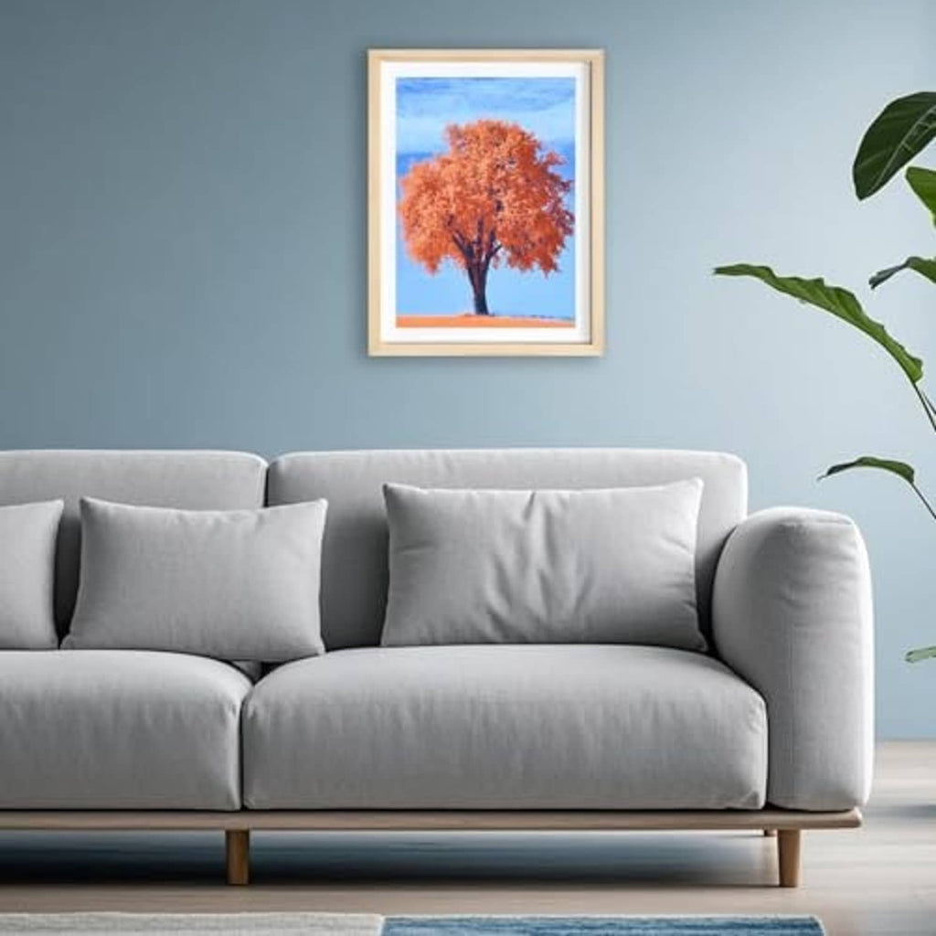 Small natural wood picture frame hanging in a living room, featuring orange tree art