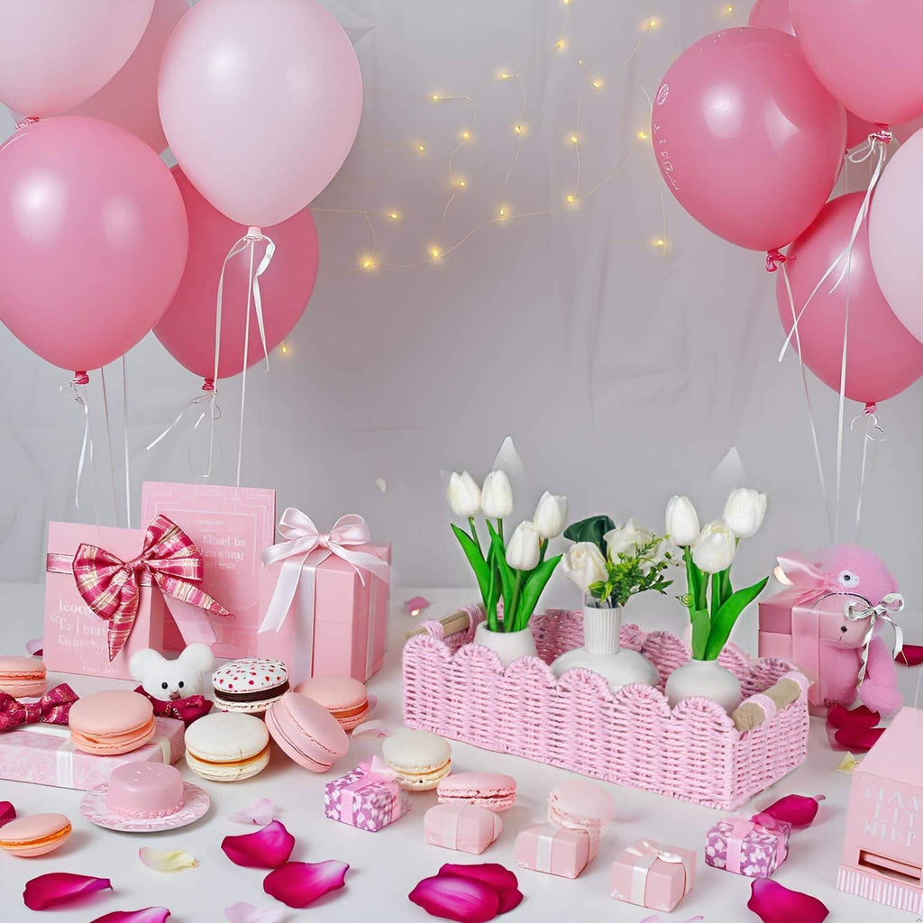 Pink paper rope scalloped gift basket holding white tulips on a party table