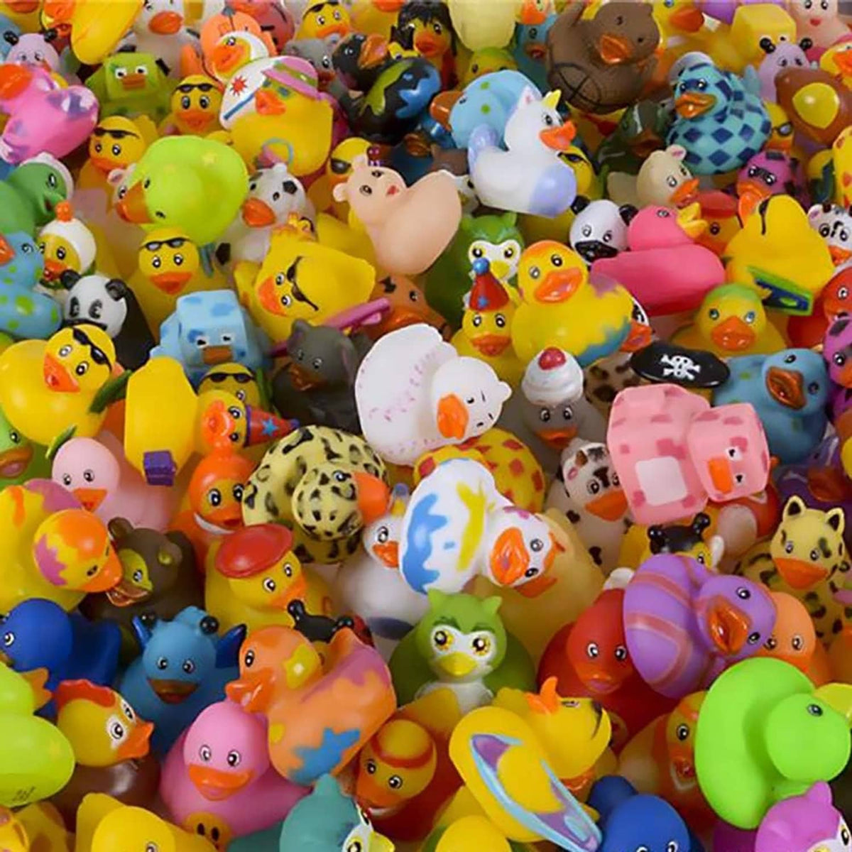 Mixed-color rubber duck toy pile with many small ducks, colorful designs packed together