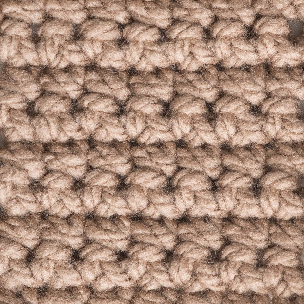 Taupe chunky yarn texture close-up with looped, nubby stitches