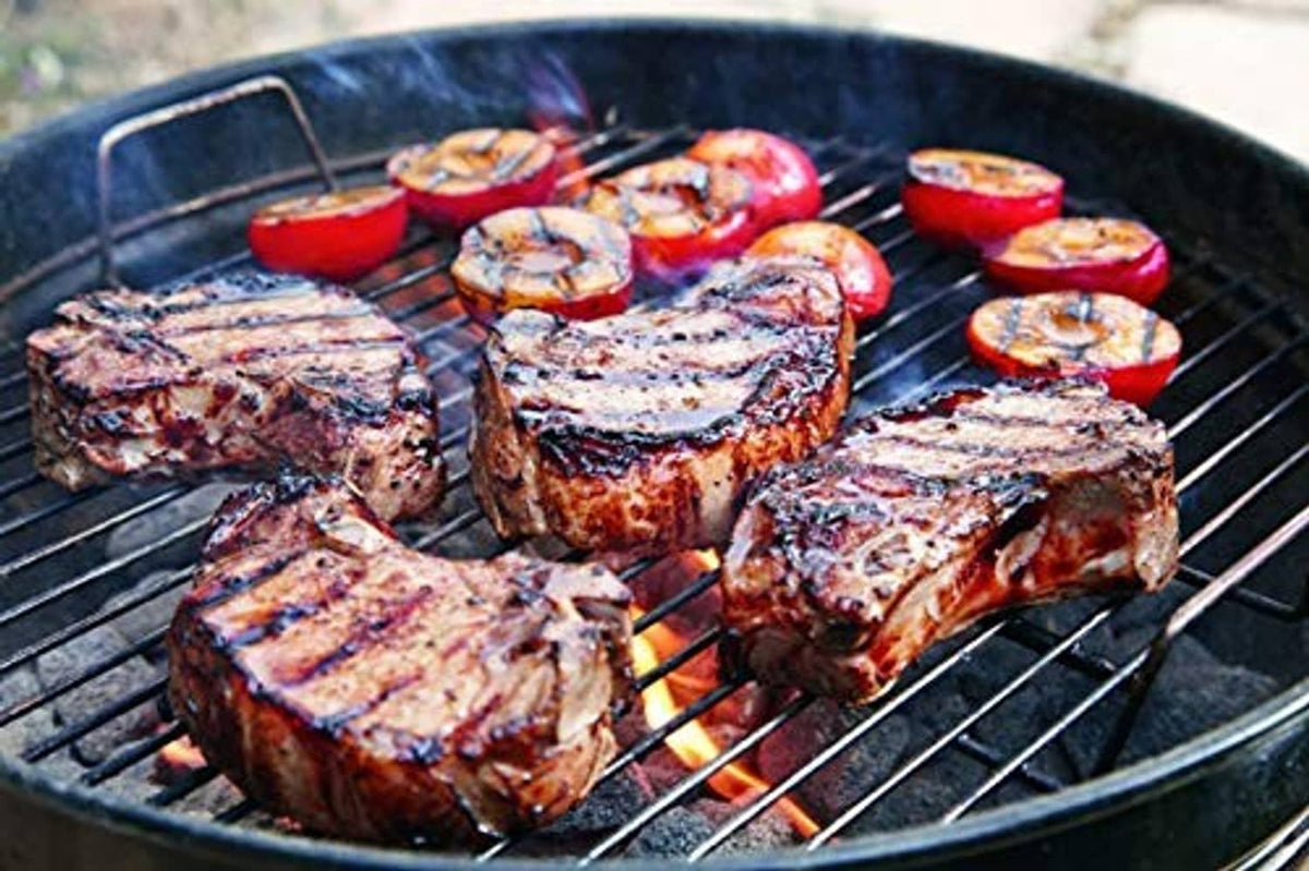 Grilled meat and vegetables on a stainless wire cooking grate